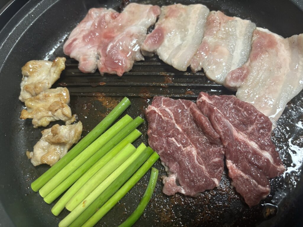 家焼肉の食材（鶏ハラミ・牛ツラミ・豚バラ・野菜・ビール）を並べた節約焼肉の実例