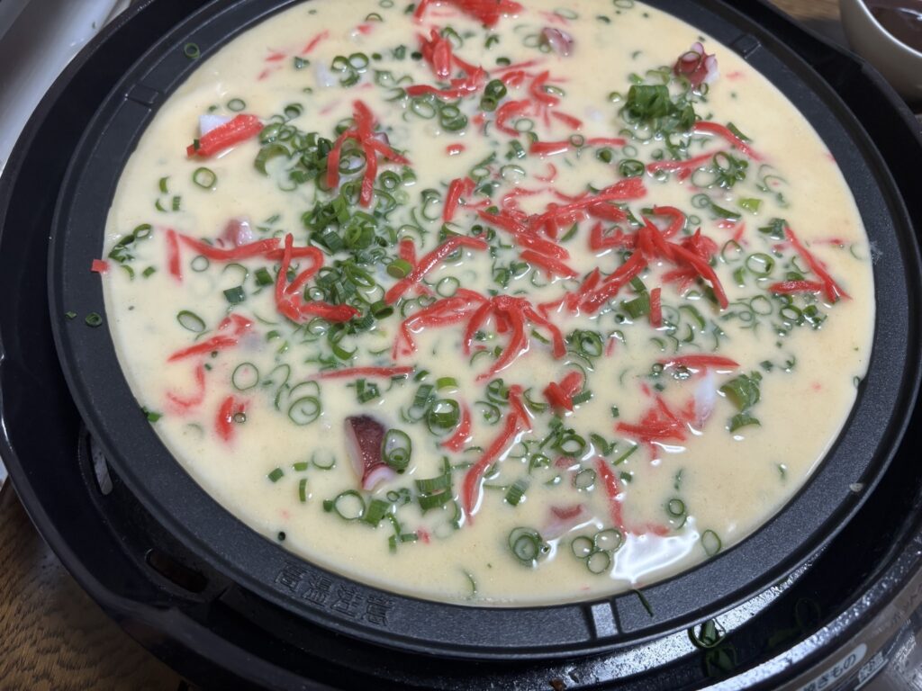 たこ焼き器に生地を流して焼き始めた様子