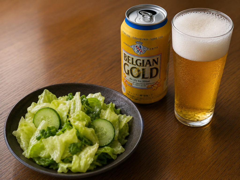 ベルジャンゴールドの缶と泡の立ったビールグラスとつまみのサラダ