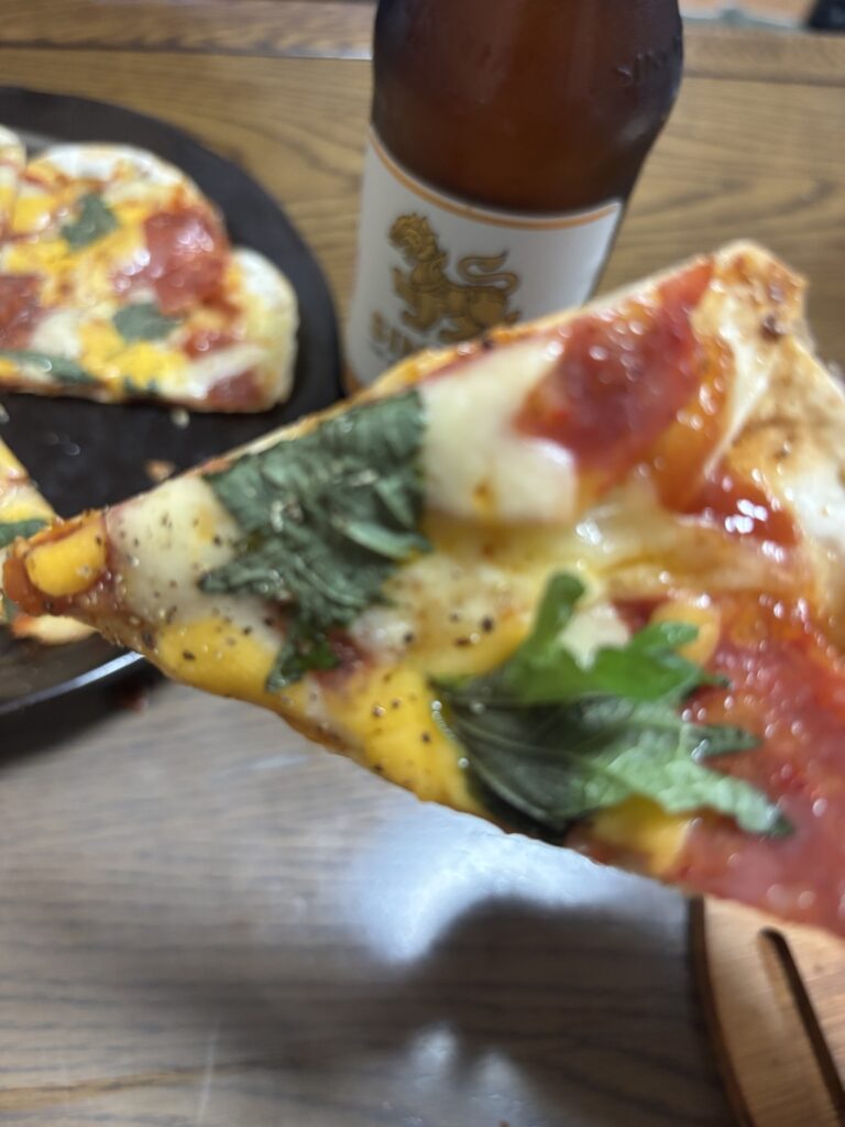 チーズとサラミと大葉をのせた餃子の皮ピザの断面アップ