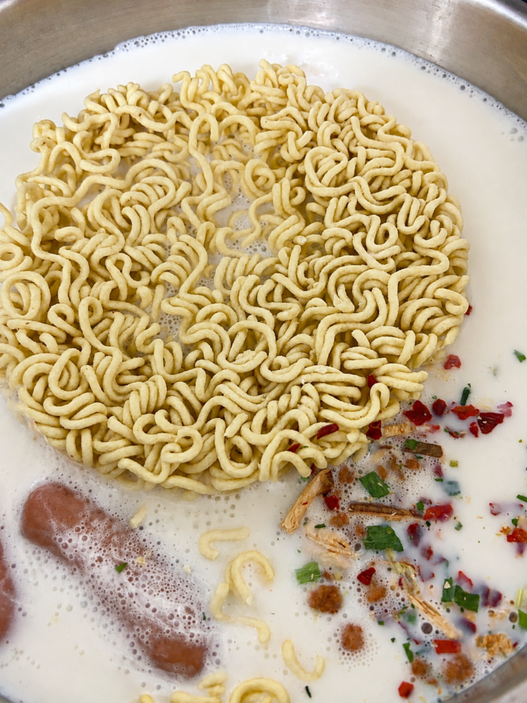 牛乳入りのスープに辛ラーメンの麺とかやくを入れたところ
