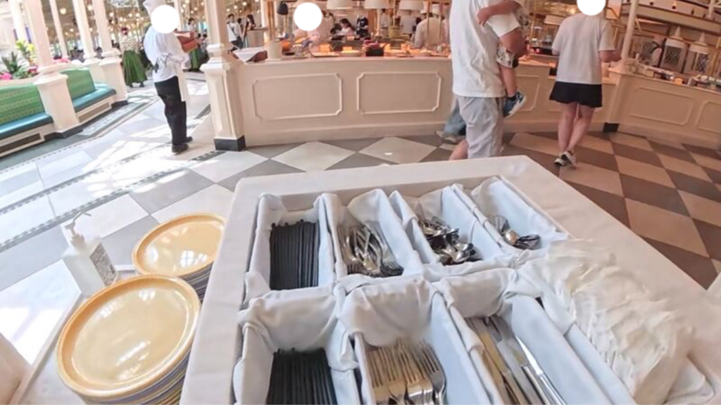 東京ディズニーランドのクリスタルパレス・レストラン店内とブッフェ台と皿とカトラリーが並ぶコーナー