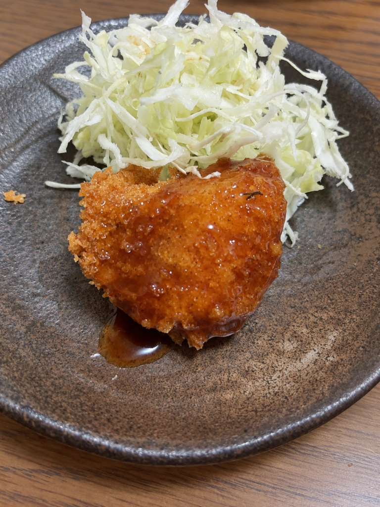 ソースをかけた一口サイズのタラフライと千切りキャベツ