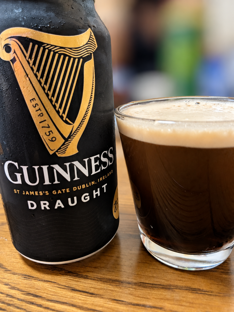 ギネス ドラフト缶とクリーミーな泡が浮かぶ黒ビール