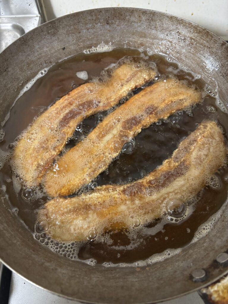 豚バラチチャロンを低温でじっくり揚げている様子