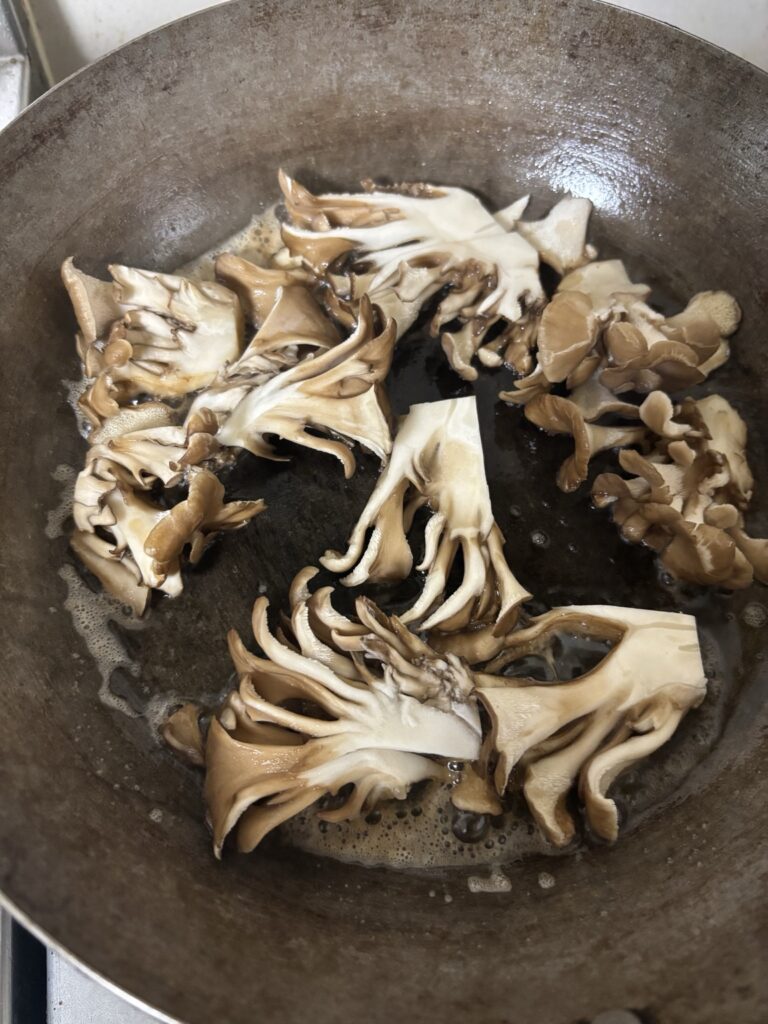 舞茸バターソテーをフライパンで焼き付けている様子