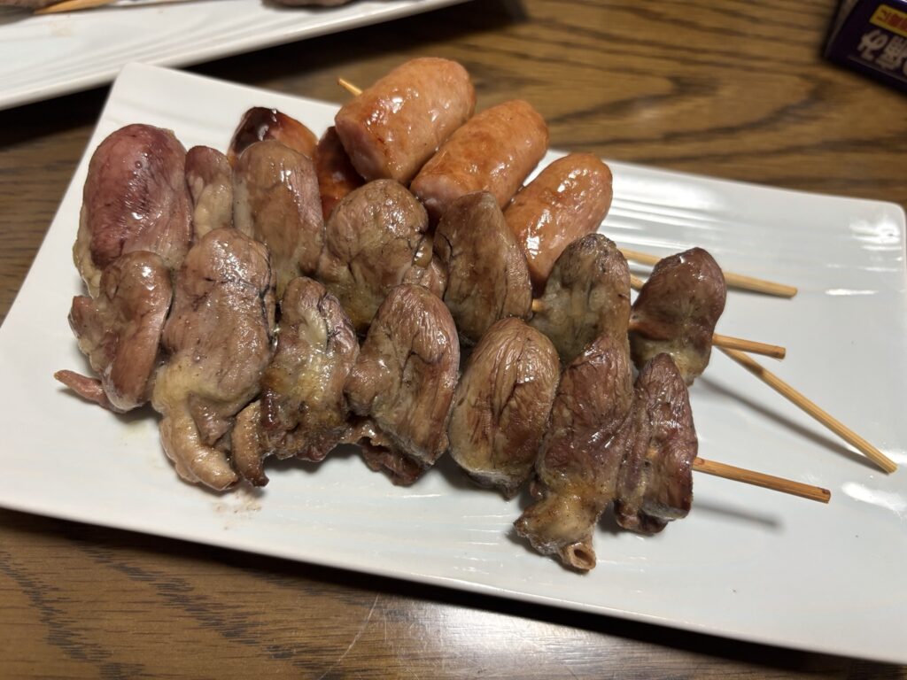 鶏心臓や豚タンの串焼きとソーセージを盛り付けた家飲み用の串焼き写真
