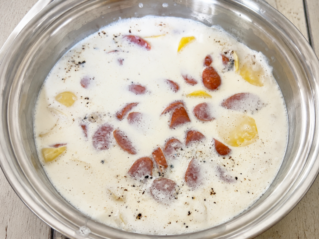 牛乳にじゃがいもとソーセージを加えたところ