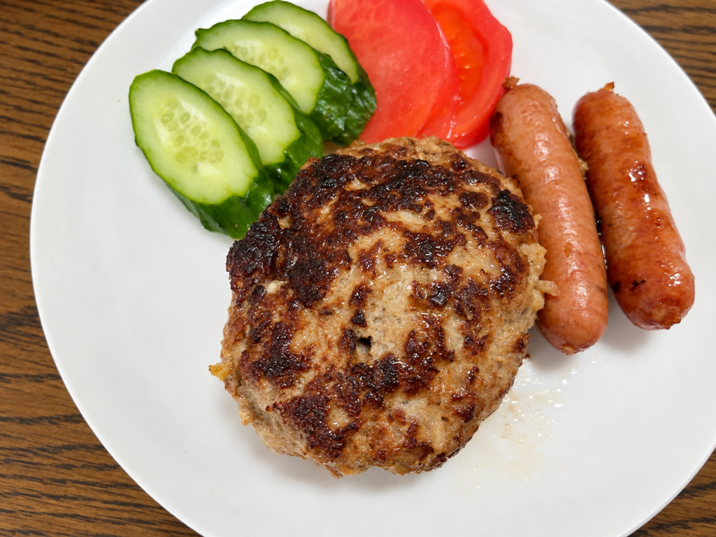 冷凍舞茸を混ぜ込んで焼いたハンバーグとウインナー、きゅうり、トマトの盛り付け